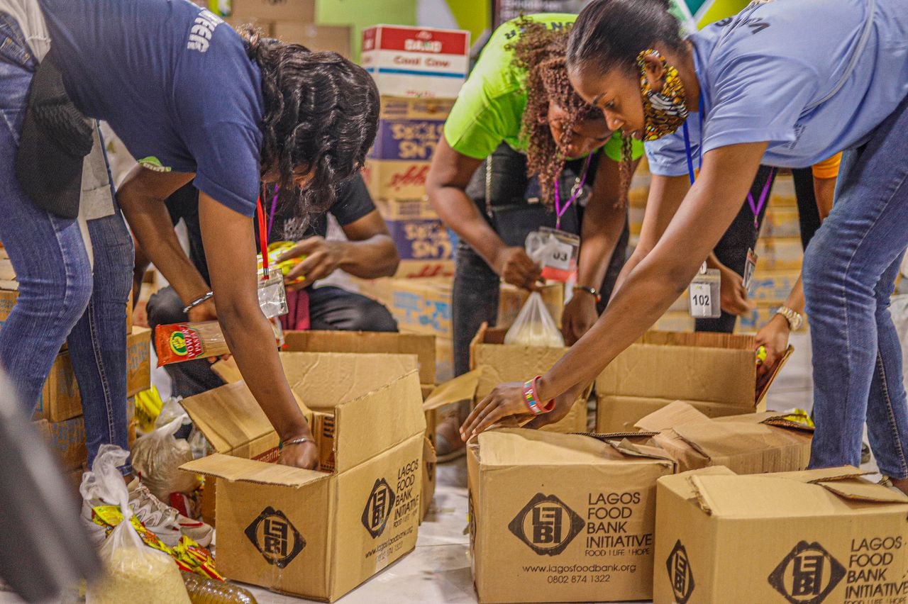 Free Team of volunteers sorting and packing food donations for a local charity initiative. Stock Photo